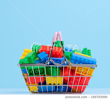 Plastic colorful building blocks in a miniature metal shopping cart, educational game for children 100783000