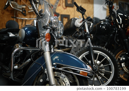 Motorcycles range in garage shop, repaired motorbikes ready for selling 100783199
