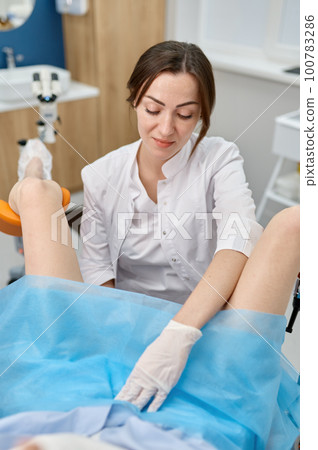Doctor conducting gynecological routine examination of young woman 100783286