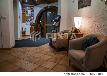 Armchairs around side table with illuminated decor arranged by wall in room of hotel Armchairs around side table with illuminated decor arranged by wall in room of hotel 100784098