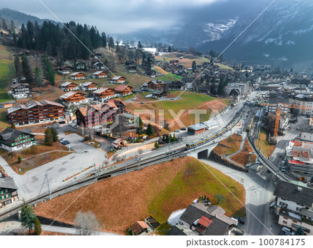 Aerial panorama of the Grindelwald, Switzerland village view near Swiss Alps mountains panorama landscape. Famous Train with Jungfrau Mountain on Sunny Day in Grindelwald Aerial panorama of the Grindelwald, Switzerland village view near Swiss Alps mountains panorama landscape. Famous Train with Jungfrau Mountain on Sunny Day in Grindelwald 100784175