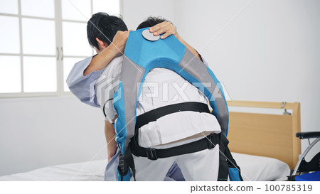 A nurse holding a patient in a power assist suit Transfer assistance equipment 100785319