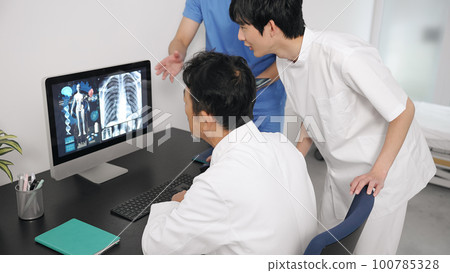 Group of medical workers in a meeting looking at a computer 100785328