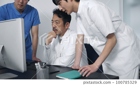 一群醫務人員在開會時看著電腦 一群醫務人員在開會時看著電腦 100785329