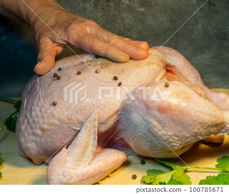 Rubdown chicken with pepper. Rubdown pepper chicken. Peppering meat. Food preparation. Applying spices to a whole chicken Rubdown chicken with pepper. Rubdown pepper chicken. Peppering meat. Food preparation. Applying spices to a whole chicken 100785671