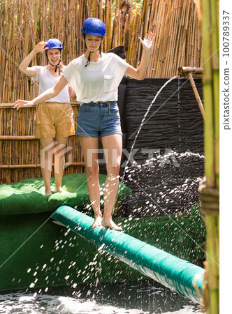 People passing horizontal bar at adventure park People passing horizontal bar at adventure park 100789337