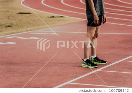 站在田徑跑道起跑線上的男賽跑者 100789342