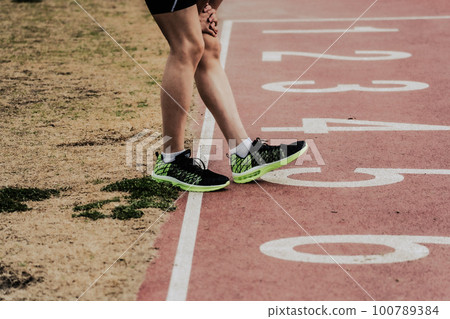 Runners warming up before the start on an athletics track 100789384