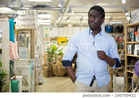 Pensive african american man visiting home furnishings store Pensive african american man visiting home furnishings store 100789432
