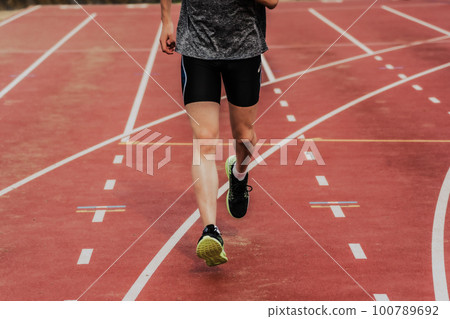 男子賽跑運動員在田徑場的跑道上起跑 100789692