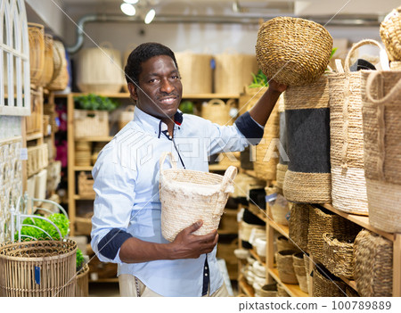 African american man buying wicker basket in household goods store African american man buying wicker basket in household goods store 100789889