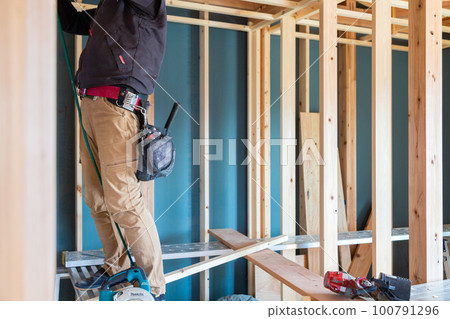 Carpenter working in a newly built detached house 100791296
