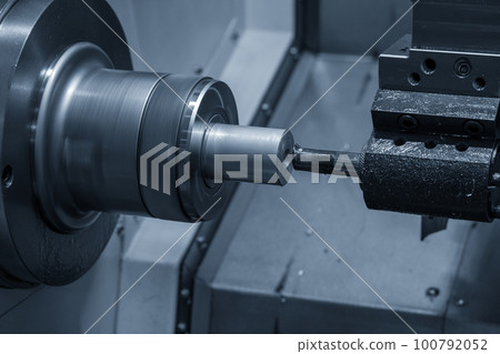 The  CNC lathe machine boring  cutting the metal shaft parts. 100792052