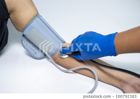 Doctor checking patient blood pressure 100792383