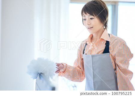 woman cleaning the dust in the room 100795225