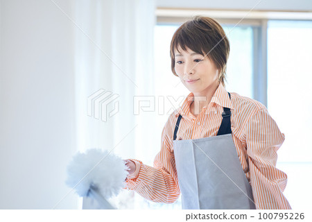 woman cleaning the dust in the room 100795226
