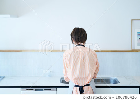 一個女人在廚房洗碗的後視圖 一個女人在廚房洗碗的後視圖 100796426