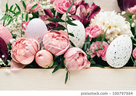Easter eggs with beautiful rich bouquet of spring flowers on wooden background. Happy Easter full frame pink flowers Easter eggs with beautiful rich bouquet of spring flowers on wooden background. Happy Easter full frame pink flowers 100797884