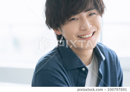 A young man smiling looking at the camera A young man smiling looking at the camera 100797891