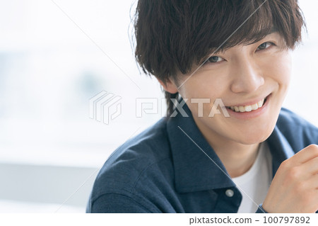 A young man smiling looking at the camera A young man smiling looking at the camera 100797892