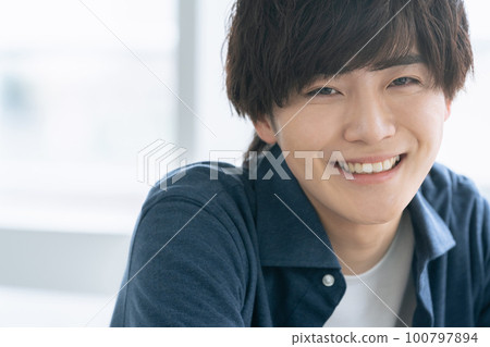 A young man smiling looking at the camera A young man smiling looking at the camera 100797894