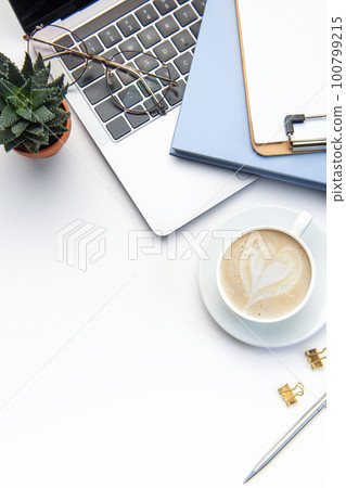 Modern white office desk table with laptop, notebook and other supplies. Modern white office desk table with laptop, notebook and other supplies. 100799215