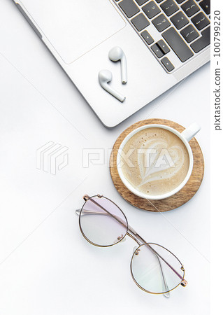 Modern white office desk table with laptop, notebook and other supplies. 100799220