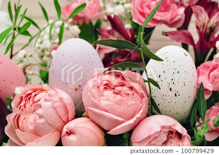Easter eggs with beautiful rich bouquet of spring flowers on wooden background. Happy Easter full frame pink flowers closeup 100799429