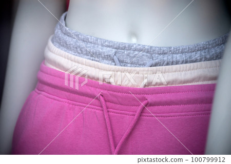 Closeup of grey and pink sport wear pants collection in a fashion store showroom Closeup of grey and pink sport wear pants collection in a fashion store showroom 100799912