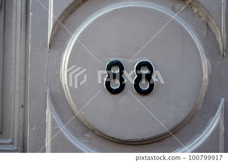 Closeup of 88 number on the wooden facade of house Closeup of 88 number on the wooden facade of house 100799917