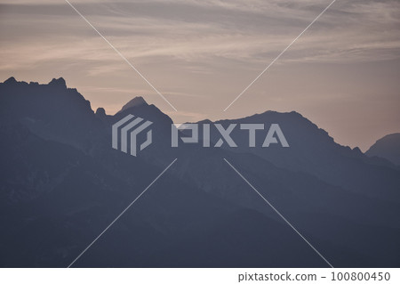 Mountains silhouette with peaks in the morning mist Saalfelden, Salzburg, Austria Mountains silhouette with peaks in the morning mist Saalfelden, Salzburg, Austria 100800450