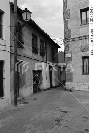 Vertical black and white shot of an old town alley in Alcala de Henares, Spain Vertical black and white shot of an old town alley in Alcala de Henares, Spain 100800452