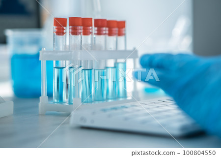 A female researcher sits at a workplace in a laboratory, behind a personal computer monitor. A female researcher sits at a workplace in a laboratory, behind a personal computer monitor. 100804550