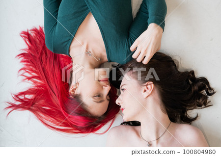 Top view of caucasian women lying and kissing.  100804980