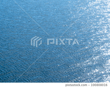 平靜的海面反射著陽光和火花。 平靜的海面反射著陽光和火花。 100808016