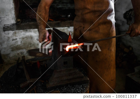 The blacksmith forge the hot metal 100811337