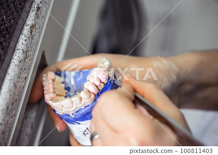 Dental technician working Dental technician working 100811403