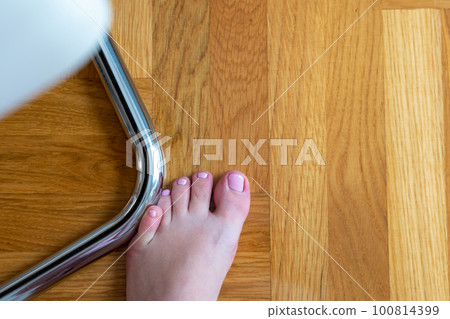 Woman hit furniture with the little toe. Incident at home. Injury of foot little finger Woman hit furniture with the little toe. Incident at home. Injury of foot little finger 100814399