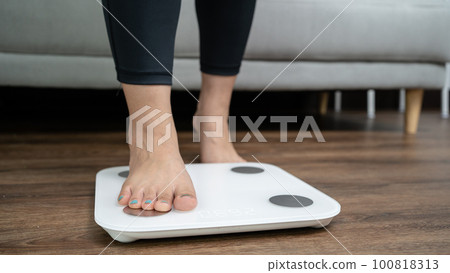 feet standing on electronic scales for weight control. Measurement instrument in kilogram for a diet control feet standing on electronic scales for weight control. Measurement instrument in kilogram for a diet control 100818313