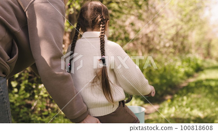 mother teaches little child daughter ride bike park. happy family. kid child rides two-wheeled bicycle. transport with pedals. mate with girl daughter park have fun bicycle spring day. family concept 100818608