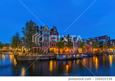 Amsterdam Netherlands, night city skyline at canal waterfront 100820198
