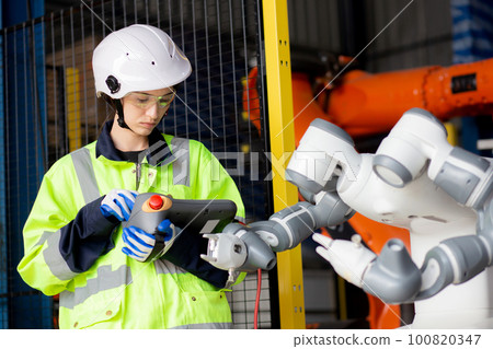 Young engineer woman checking and maintenance machine robot arms. Young engineer woman checking and maintenance machine robot arms. 100820347
