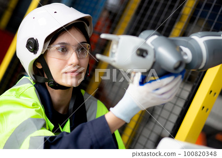 Young engineer woman checking and maintenance machine robot arms. Young engineer woman checking and maintenance machine robot arms. 100820348
