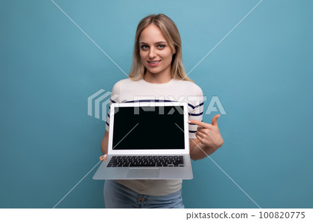 focused woman showing laptop screen with mockup on blue background 100820775