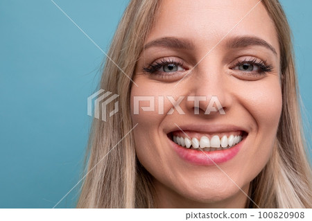 portrait of a woman with a snow-white Hollywood smile and on a blue background 100820908
