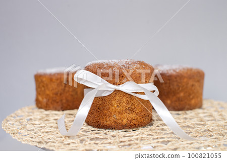 Sponge cake with a white bow is on a napkin Sponge cake with a white bow is on a napkin 100821055