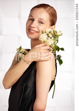Beautiful young with special needs woman with flowers in her hand holding a flower, woman in black dress. Diversity women with disability and flowers. Beautiful young with special needs woman with flowers in her hand holding a flower, woman in black dress. Diversity women with disability and flowers. 100821544