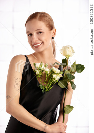 Beautiful young with special needs woman with flowers in her hand holding a flower, woman in black dress. Diversity women with disability and flowers. Beautiful young with special needs woman with flowers in her hand holding a flower, woman in black dress. Diversity women with disability and flowers. 100821558