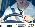 Middle-aged male driver's hand holding the steering wheel while screaming 100821832