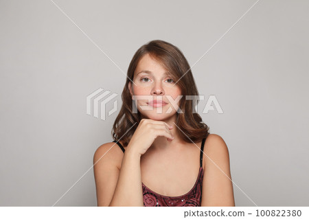 Beautiful young woman with clean skin and curly brown hair portrait 100822380